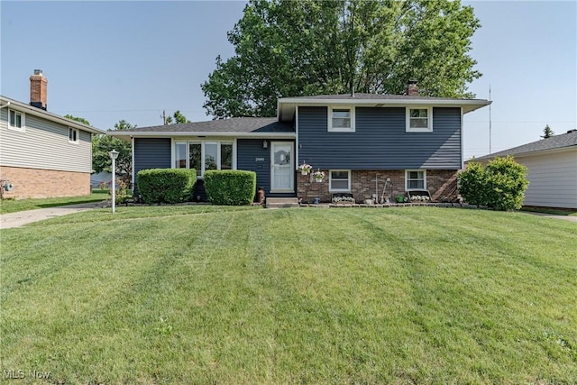 2880 Hetzel Dr, Parma, OH 44134 - tri-level home featuring a front yard, a chimney, and brick siding