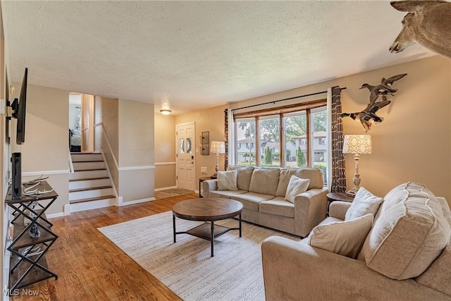 2880 Hetzel Dr, Parma, OH 44134 - living area featuring a textured ceiling, wood finished floors, and stairs