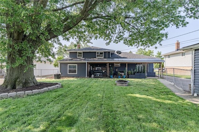 2880 Hetzel Dr, Parma, OH 44134 - back of house with a fenced backyard, an outdoor fire pit, and a chimney