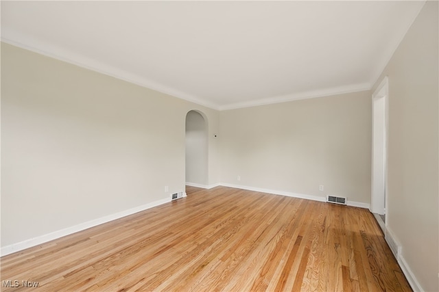 10212 Grace Ave, Garfield Heights, OH 44125 - empty room featuring arched walkways, light wood finished floors, and crown molding