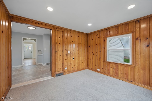 10212 Grace Ave, Garfield Heights, OH 44125 - empty room featuring arched walkways, recessed lighting, light carpet, and wooden walls