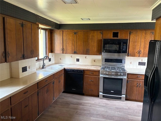 989 Orchard Hill Cir, Massillon, OH 44646 - kitchen with black appliances, decorative backsplash, light wood finished floors, and light countertops