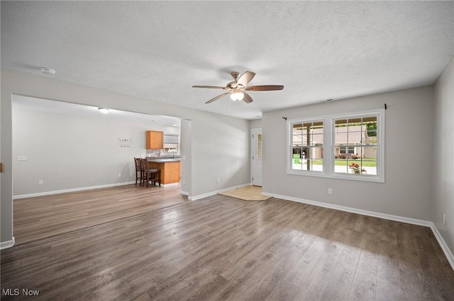 3031 Logan Ln Unit 1, Rock Creek, OH 44084 - unfurnished living room with ceiling fan, wood finished floors, and a textured ceiling
