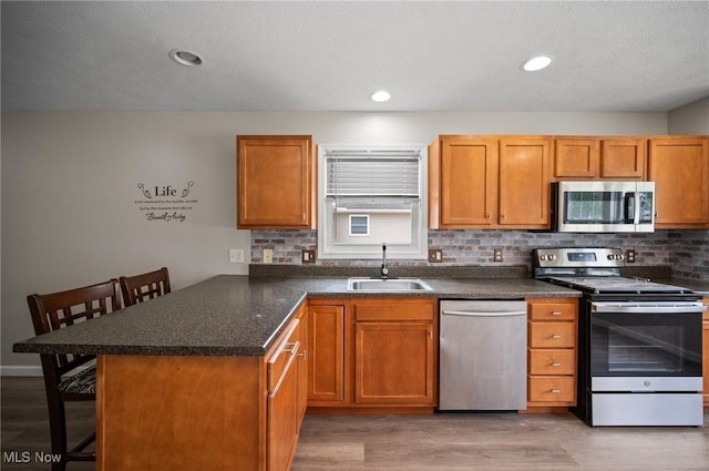 3031 Logan Ln Unit 1, Rock Creek, OH 44084 - kitchen featuring appliances with stainless steel finishes, a breakfast bar, a peninsula, backsplash, and recessed lighting