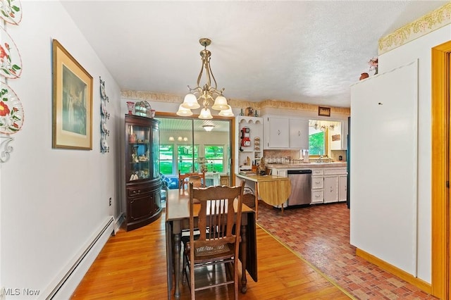 3612 Ridge Rd, Cortland, OH 44410 - dining space featuring a baseboard heating unit, light wood-style flooring, a chandelier, and a textured ceiling