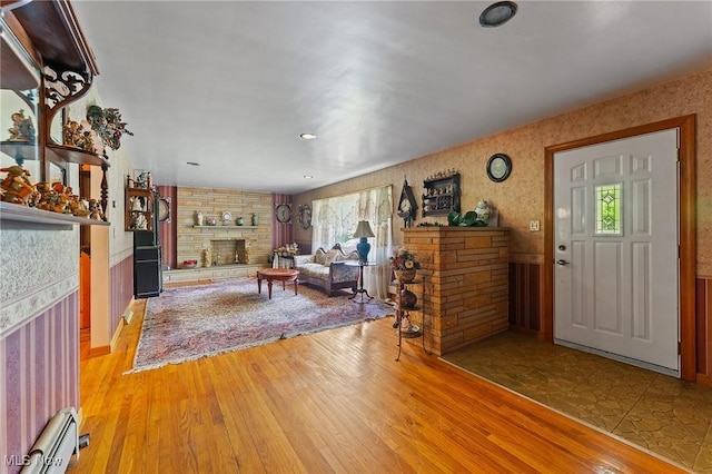 3612 Ridge Rd, Cortland, OH 44410 - living room featuring a stone fireplace, wood finished floors, and a baseboard heating unit