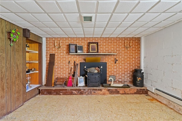 3612 Ridge Rd, Cortland, OH 44410 - unfurnished living room featuring built in features, a wood stove, tile patterned floors, a baseboard radiator, and wood walls