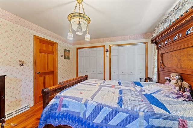 3612 Ridge Rd, Cortland, OH 44410 - bedroom with wallpapered walls, multiple closets, wood finished floors, and a baseboard radiator