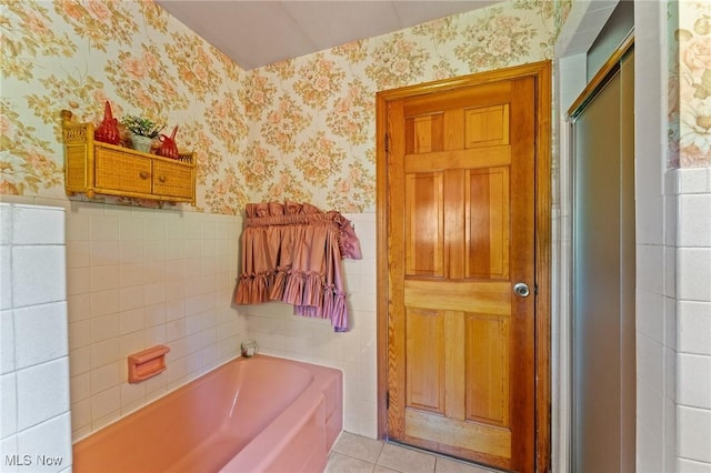 3612 Ridge Rd, Cortland, OH 44410 - bathroom featuring wallpapered walls, a wainscoted wall, a bath, tile walls, and tile patterned floors