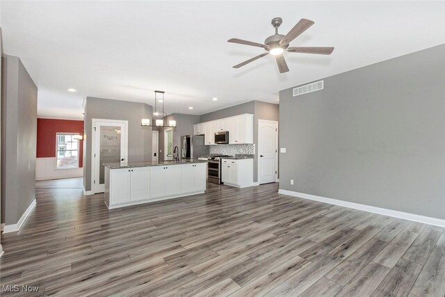 686 Outrigger Cv, Painesville, OH 44077 - kitchen featuring appliances with stainless steel finishes, open floor plan, wood finished floors, ceiling fan, and recessed lighting