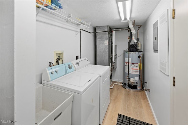 662 2nd St Unit 2, Fairport Harbor, OH 44077 - laundry area with gas water heater, washer and clothes dryer, light wood-style floors, and a textured ceiling