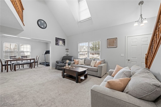 662 2nd St Unit 2, Fairport Harbor, OH 44077 - living room featuring high vaulted ceiling, light colored carpet, stairway, and a chandelier