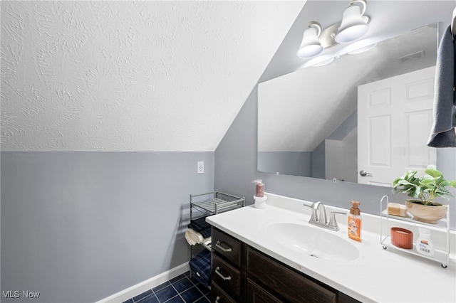 662 2nd St Unit 2, Fairport Harbor, OH 44077 - bathroom featuring vanity, tile patterned flooring, lofted ceiling, and a textured ceiling