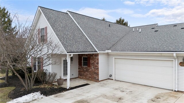 662 2nd St Unit 2, Fairport Harbor, OH 44077 - view of front of property with driveway, a garage, roof with shingles, and brick siding
