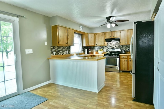 2847 Selkirk Bush Rd SW, Warren, OH 44481 - kitchen with stainless steel appliances, extractor fan, a peninsula, decorative backsplash, and a textured ceiling