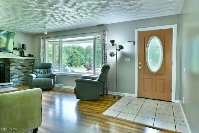 2847 Selkirk Bush Rd SW, Warren, OH 44481 - entrance foyer with wood finished floors, a fireplace, and a textured ceiling