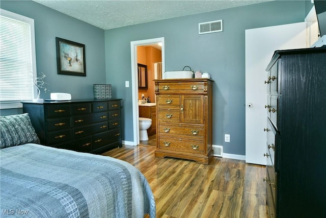 2847 Selkirk Bush Rd SW, Warren, OH 44481 - bedroom featuring wood finished floors, a textured ceiling, and ensuite bathroom