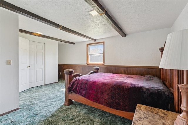 3917 Oxford Dr, Lorain, OH 44053 - bedroom featuring a textured ceiling, wood walls, carpet floors, beamed ceiling, and wainscoting