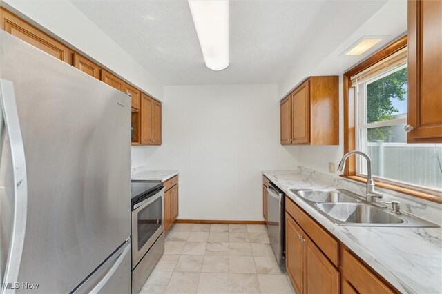 3917 Oxford Dr, Lorain, OH 44053 - kitchen with stainless steel appliances, brown cabinets, light stone countertops, and light marble finish flooring