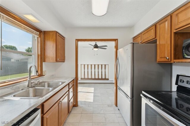 3917 Oxford Dr, Lorain, OH 44053 - kitchen featuring stainless steel electric range, dishwashing machine, ceiling fan, light countertops, and brown cabinetry