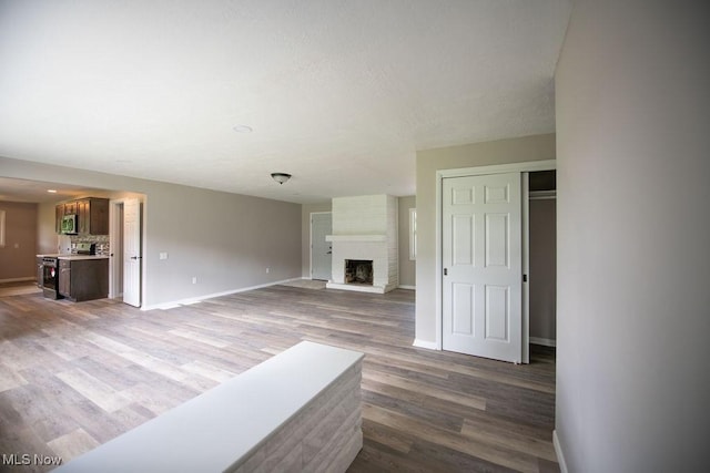 4029 Minard Rd NW, Dover, OH 44622 - unfurnished living room featuring wood finished floors and a brick fireplace
