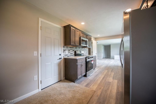 4029 Minard Rd NW, Dover, OH 44622 - kitchen with appliances with stainless steel finishes, dark brown cabinets, tasteful backsplash, recessed lighting, and light countertops