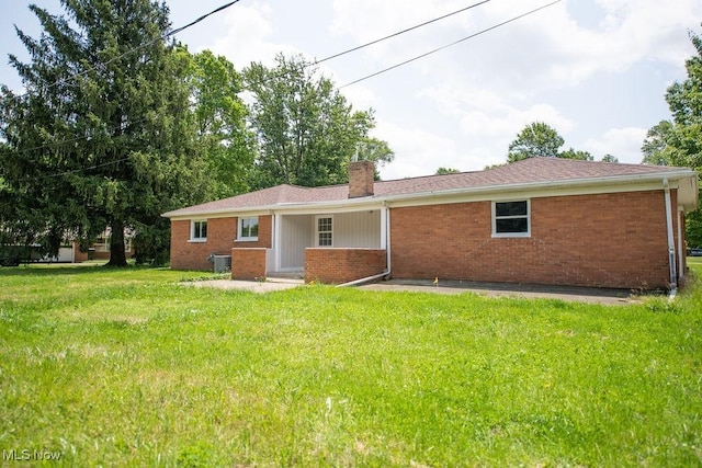 4029 Minard Rd NW, Dover, OH 44622 - rear view of property with brick siding, a chimney, and a yard