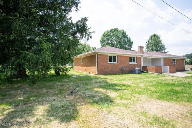 4029 Minard Rd NW, Dover, OH 44622 - rear view of house featuring brick siding, a chimney, and a lawn