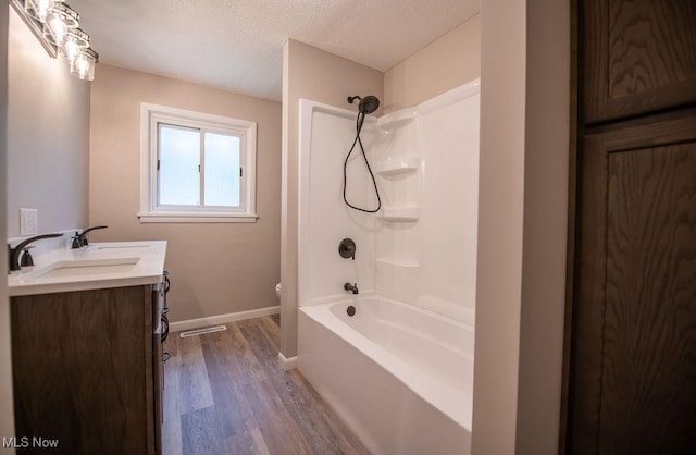 4029 Minard Rd NW, Dover, OH 44622 - full bath featuring wood finished floors, double vanity, a textured ceiling, and bathing tub / shower combination