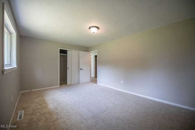 4029 Minard Rd NW, Dover, OH 44622 - unfurnished bedroom featuring light colored carpet, a closet, and a textured ceiling