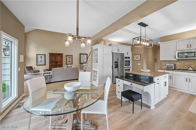 196 Chisholm Ct, Aurora, OH 44202 - dining space with a chandelier, light wood-style floors, and vaulted ceiling