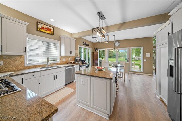 196 Chisholm Ct, Aurora, OH 44202 - kitchen with appliances with stainless steel finishes, light wood-type flooring, tasteful backsplash, a chandelier, and recessed lighting