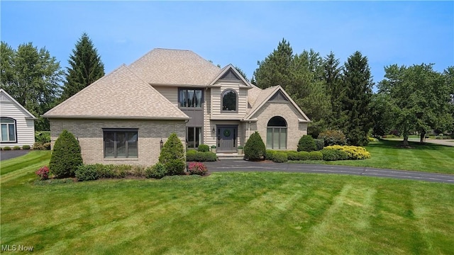 196 Chisholm Ct, Aurora, OH 44202 - traditional home with brick siding, a front yard, and a shingled roof