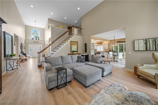 196 Chisholm Ct, Aurora, OH 44202 - living room with a high ceiling, stairs, light wood-style flooring, and recessed lighting