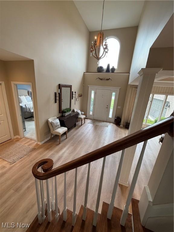 196 Chisholm Ct, Aurora, OH 44202 - entryway with a towering ceiling, wood finished floors, plenty of natural light, a chandelier, and stairway