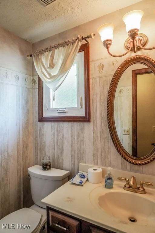 525 Marquardt Ave NE, North Canton, OH 44720 - half bathroom with vanity, a textured ceiling, and wooden walls