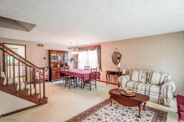 525 Marquardt Ave NE, North Canton, OH 44720 - living room featuring a textured ceiling, wallpapered walls, carpet flooring, and stairs