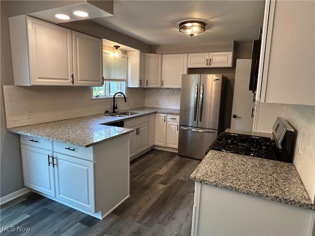 7295 Clovermeade Ave, Poland, OH 44514 - kitchen featuring freestanding refrigerator, gas range, white cabinets, a peninsula, and dark wood finished floors
