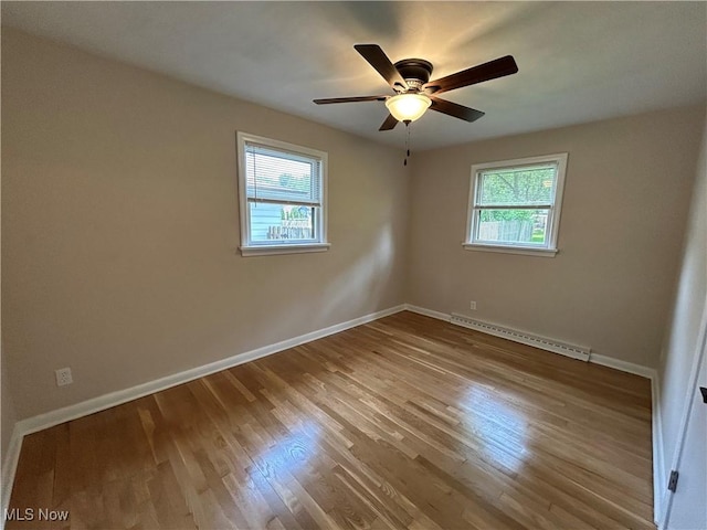 7295 Clovermeade Ave, Poland, OH 44514 - empty room with a baseboard heating unit, a ceiling fan, and wood finished floors