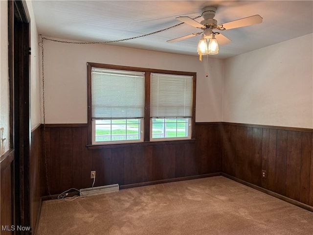 3022 Heatherbrae Dr, Poland, OH 44514 - unfurnished room with a wainscoted wall, wooden walls, a ceiling fan, carpet flooring, and a baseboard radiator