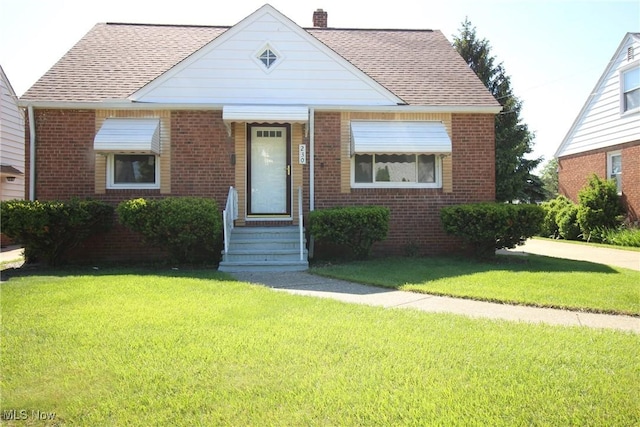 230 E 242nd St, Euclid, OH 44123 - bungalow-style house with brick siding, a front lawn, and a chimney