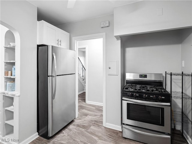 3845 Hillbrook Rd, University Heights, OH 44118 - kitchen with appliances with stainless steel finishes, white cabinets, and arched walkways