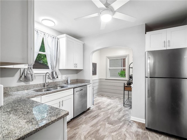 3845 Hillbrook Rd, University Heights, OH 44118 - kitchen featuring stainless steel appliances, stone countertops, ceiling fan, arched walkways, and white cabinets