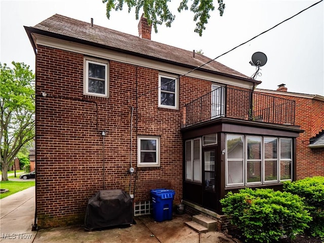 3845 Hillbrook Rd, University Heights, OH 44118 - rear view of house with a balcony, brick siding, a chimney, a sunroom, and entry steps