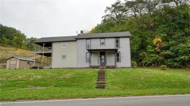 59590 Vocational Rd, Byesville, OH 43723 - traditional home featuring a storage unit, a front lawn, a chimney, a balcony, and covered porch