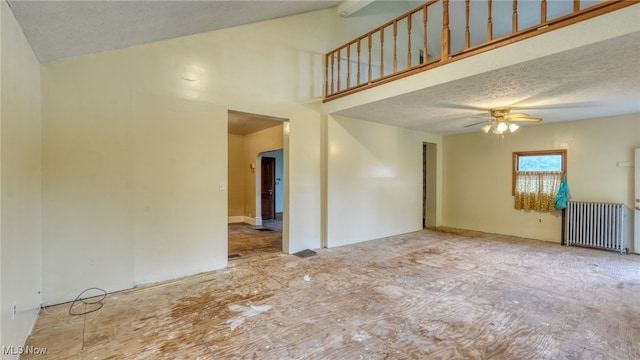 59590 Vocational Rd, Byesville, OH 43723 - spare room with radiator, a ceiling fan, a textured ceiling, and high vaulted ceiling