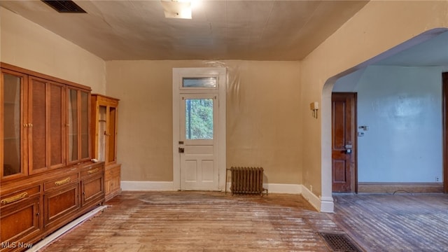 59590 Vocational Rd, Byesville, OH 43723 - entrance foyer featuring radiator, arched walkways, and hardwood / wood-style floors