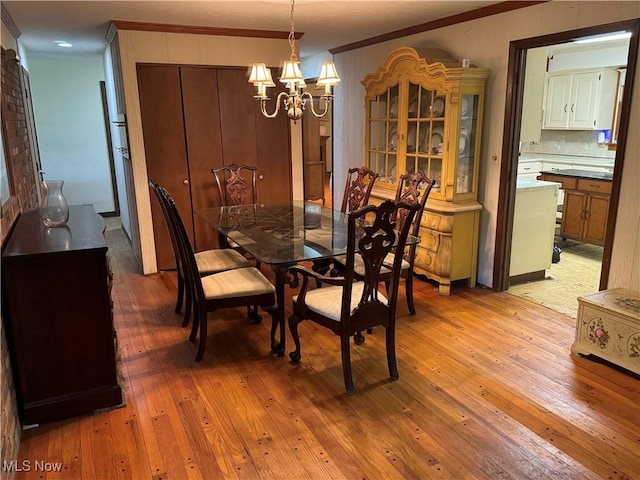 9999 Kirtland Chardon Rd, Chardon, OH 44024 - dining space featuring crown molding, light wood-style floors, and a chandelier
