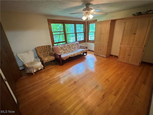 9999 Kirtland Chardon Rd, Chardon, OH 44024 - living area featuring ceiling fan, light wood-style floors, and a baseboard heating unit
