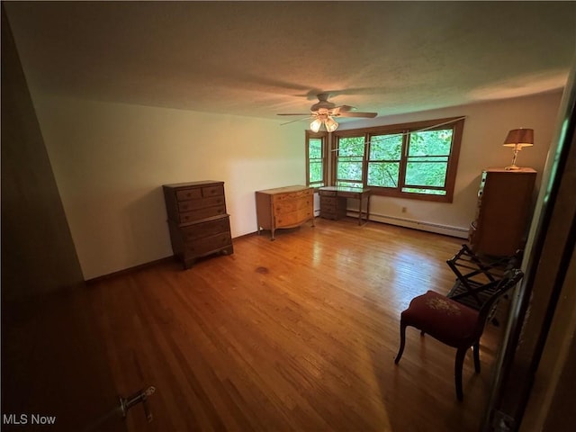 9999 Kirtland Chardon Rd, Chardon, OH 44024 - unfurnished bedroom with baseboard heating, wood finished floors, and a ceiling fan